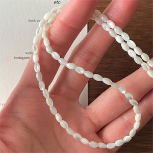 Minimalist 925 sterling silver necklace with white rice pearls held in hand for women