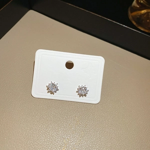 Close-up of snowflake stud earrings with sparkling cubic zirconia on a display card