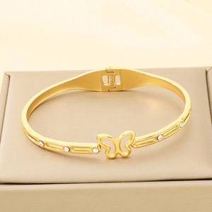 Macro shot of gold-plated butterfly bracelet with white crystals on a velvet base
