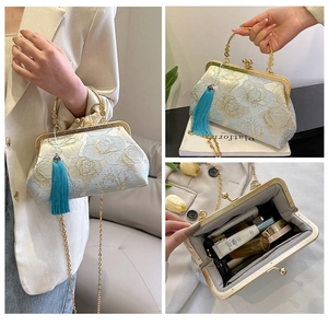 Detail of light blue embroidered shell bag with long fringe tassel and gold chain strap