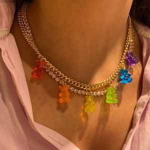 Close-up of double-layer gold chain necklace featuring seven colorful resin bear pendants