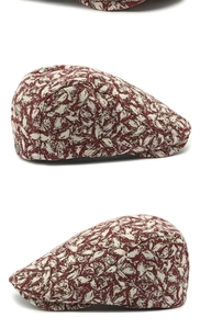 Detail view of ethnic red and white floral beret with side buckle and textured fabric