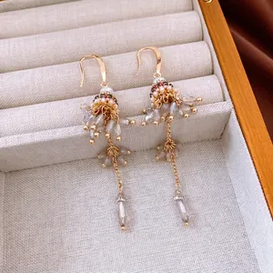 Ethnic style beaded tassel drop earrings with gold finish and faceted glass teardrops