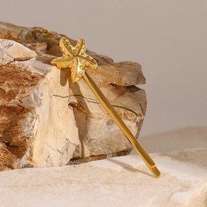 Nahaufnahme der goldenen Seestern-Haarklammer mit Details auf natürlichem Stein