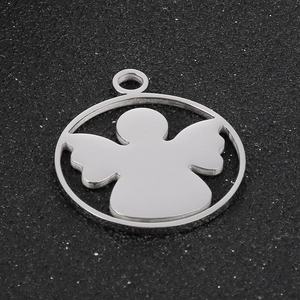 Close-up of a silver stainless steel angel silhouette pendant on black texture