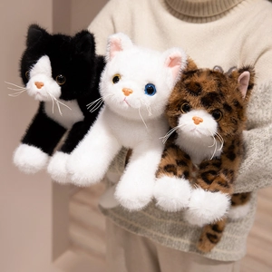 Realistic plush kittens in three colors held by a model in a warm indoor setting