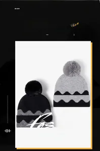 Detail showing the thick knit texture and fluffy faux fur pom-poms on the winter hats