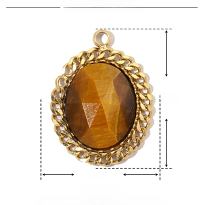 Macro view of oval tiger eye natural stone pendant with gold stainless steel border