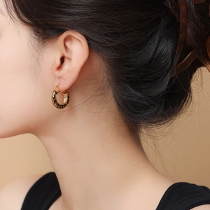14k gold plated round hoop earrings with leopard print pattern worn by a model