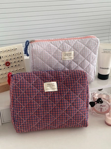 Quilted checkerboard cosmetic bags in contrasting colors with zipper and woven labels