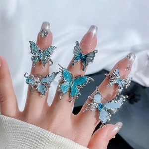 Set of five silver butterfly rings featuring blue and light blue gemstones on fingers