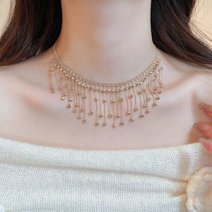 Close-up of gold multi-layer tassel lace necklace featuring small metal ball pendants
