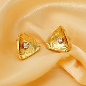 Goldene Dreieck-Ohrstecker mit Zirkon auf gelbem Seidenhintergrund im Vintage-Stil