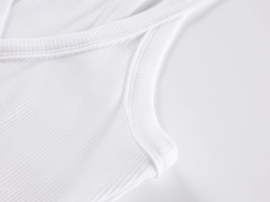 Close-up of white ribbed tank top showing high-quality knitted fabric and reinforced seams