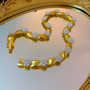 Vintage gold necklace with pearl flowers on a classic carved mirror surface