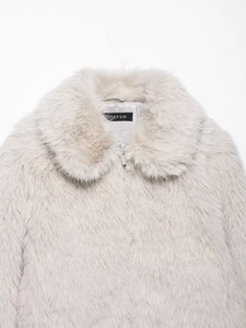 Detail of soft faux fur jacket collar and metallic zipper on a neutral beige coat