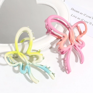 Detail of gradient butterfly hair claws with matte finish and vibrant color transitions