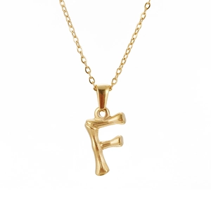 Close-up of gold stainless steel necklace with bamboo texture letter F pendant