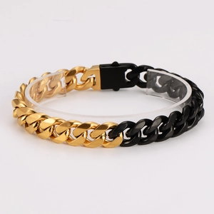 Two-tone gold and black stainless steel Cuban link bracelet displayed on acrylic stand