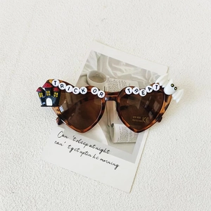 Detail of tortoise heart sunglasses with Trick or Treat lettering and Halloween charms
