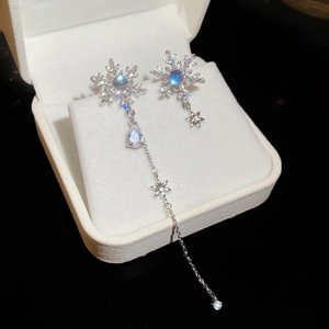 Detail of silver snowflake earrings with long tassel chain and crystals in a jewelry box