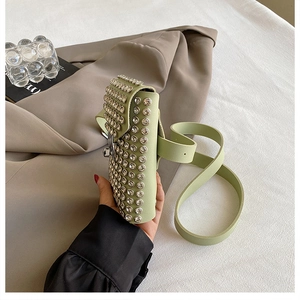 Close-up of mint green rhinestone crossbody bag with sparkling studs on leather