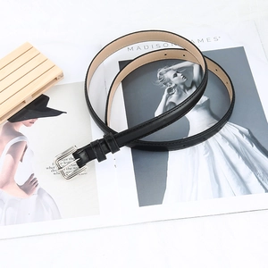 Classic black leather belt with silver pin buckle styled on a fashion magazine