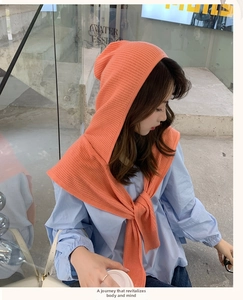 Detail of orange pink hooded knitted shawl with vertical stripe texture and tie design