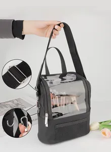 Detail view of makeup bag showing adjustable shoulder strap with metal hooks and clear PVC window