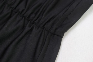 Gros plan sur les fronces et la texture du tissu d'une robe moulante noire
