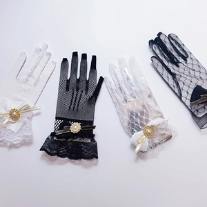 Detailed view of lace and fishnet gloves with bows and pearls in black and white