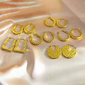 Set of six gold-plated irregular geometric hoop earrings on champagne silk fabric