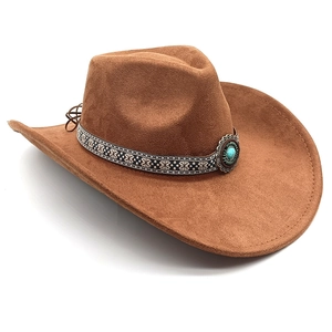 Detail of a brown suede cowboy hat with patterned band and turquoise vintage buckle