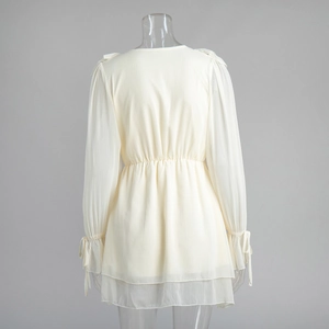 Detailed back view of off-white chiffon dress with elastic waist and ruffle hem details