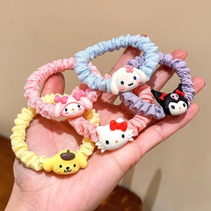 Detail showing five colorful elastic hair scrunchies with cute cartoon resin charms
