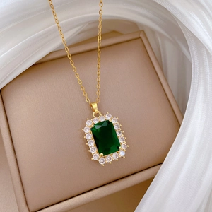 Luxurious gold titanium necklace featuring a green rectangular crystal and pavé border