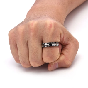 Detail of spinning stainless steel ring with white calendar date and month engraving