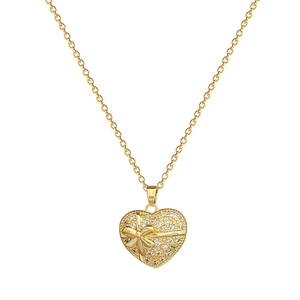 Collier élégant avec pendentif cœur doré, cristaux scintillants et un nœud 3D
