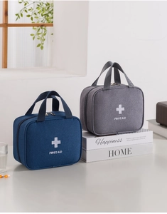 Close-up of portable first aid bags in blue and gray with a sturdy top handle