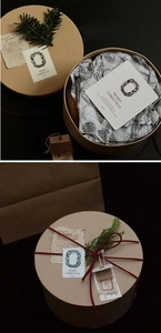 Detail of round kraft gift box with red ribbon and Christmas pine branch decoration