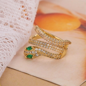 Close-up of gold snake ring with green stone eyes and micro-inlaid zircon crystals