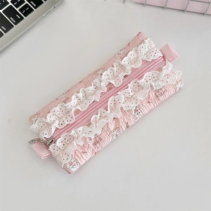 Close-up of pink quilted pencil case with white lace edges and cute flower pattern