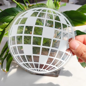 Close-up of translucent geometric globe suncatcher decal against a nature backdrop
