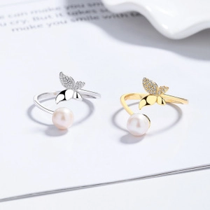 Detailed macro view of adjustable butterfly rings with white pearls and pave zirconia