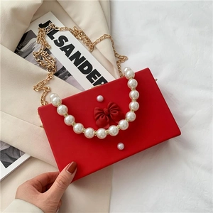 Elegant red box handbag with pearl handle, ribbon bow, and golden chain strap for women