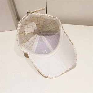 Detail view of tweed baseball cap interior with white lining and metal buckle