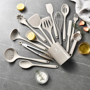 15-piece beige silicone cooking utensil set on a stylish grey marble kitchen surface