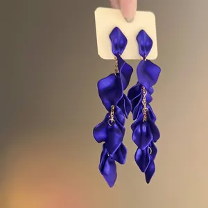Detail of dark blue velvet petal tassel earrings with elegant golden link chains