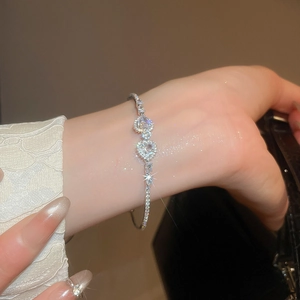 Close-up of a silver open heart bracelet with sparkling zircons on a woman's wrist