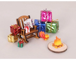 Miniature Christmas set with wooden rocking chair, colorful gift boxes, and small campfire